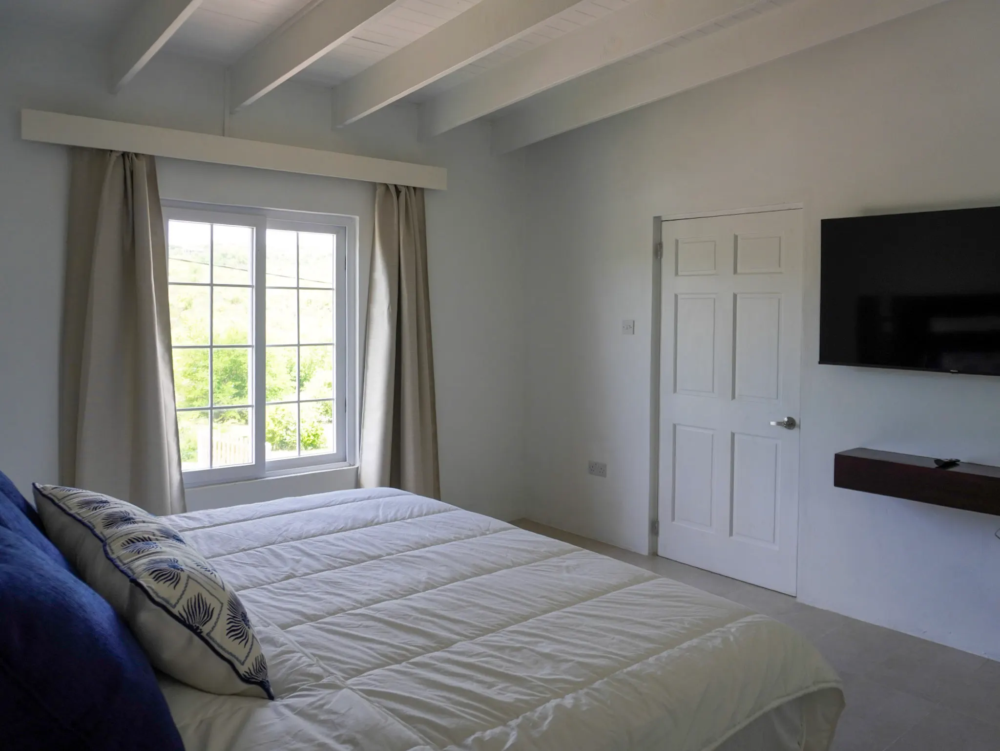 Close view of the king bed styled with linen and cushions