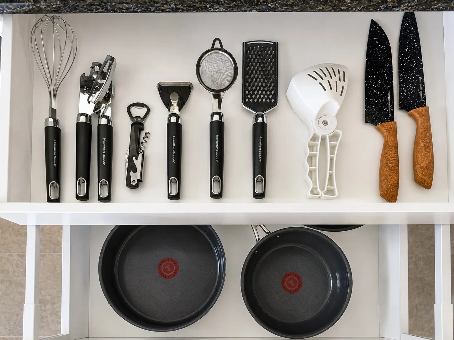 Kitchen drawer stocked with cookware, knives and utensils