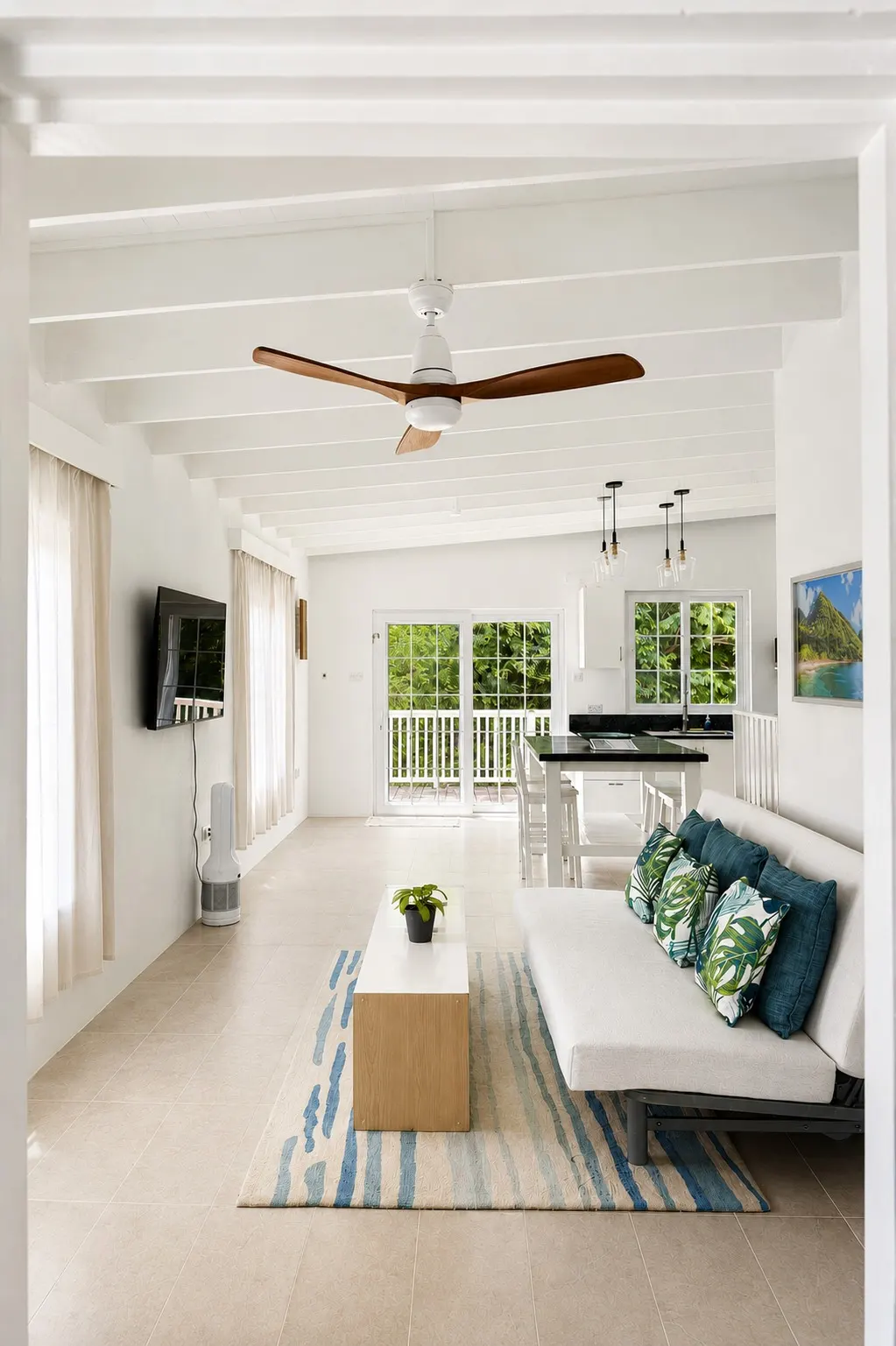Open-plan living area with palm-print cushions and a dining table