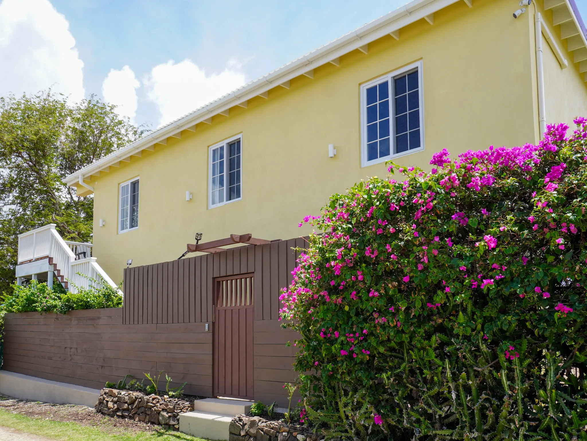 Exterior of the guesthouse framed by bougainvillea