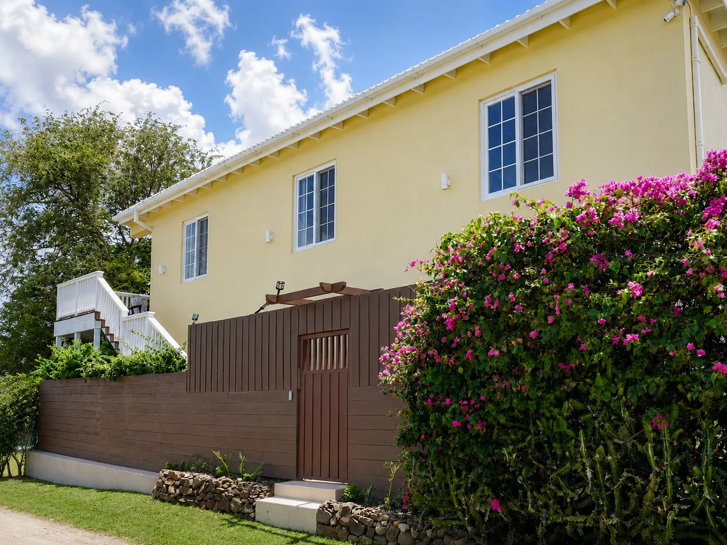 Exterior of the guesthouse framed by bougainvillea