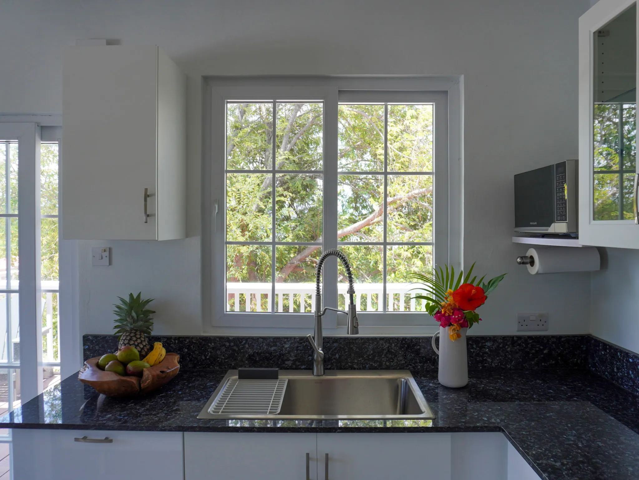 Kitchen sink beneath a window looking out to the trees