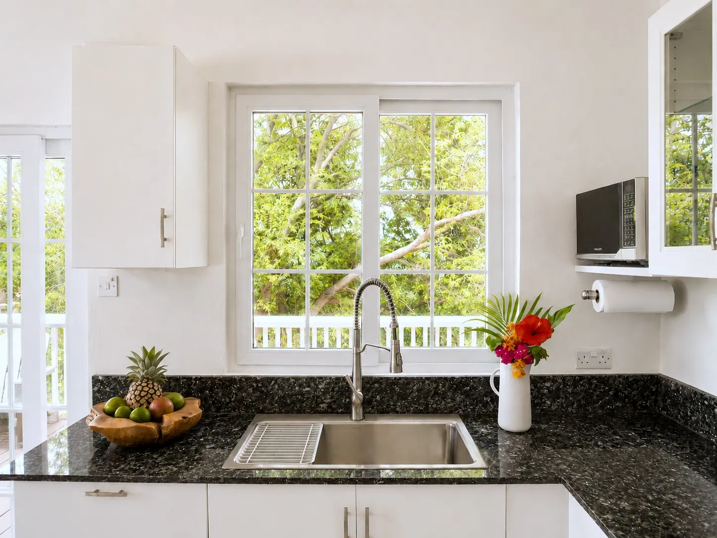 Kitchen sink beneath a window looking out to the trees