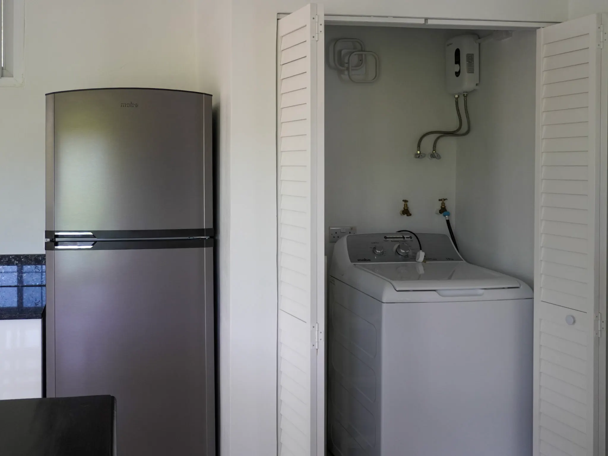 In-unit laundry area with washer and drying rack