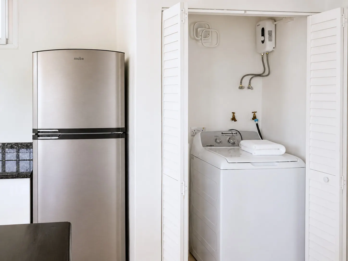 In-unit laundry closet with washing machine and water heater